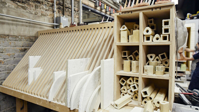 Various sized ceramic pieces stored in a wooden frame. 