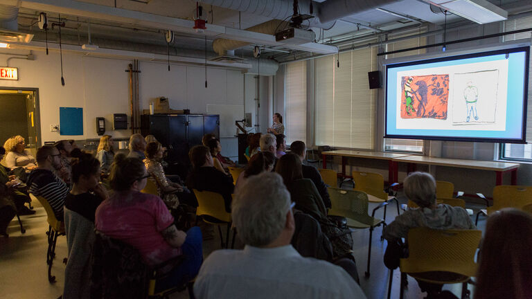 A large group of students looking at a presentation being projected.