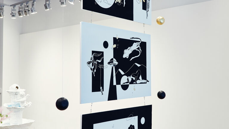 Three large black and white prints hung from the ceiling