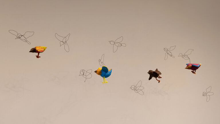 A series of birds made out of paper mache.