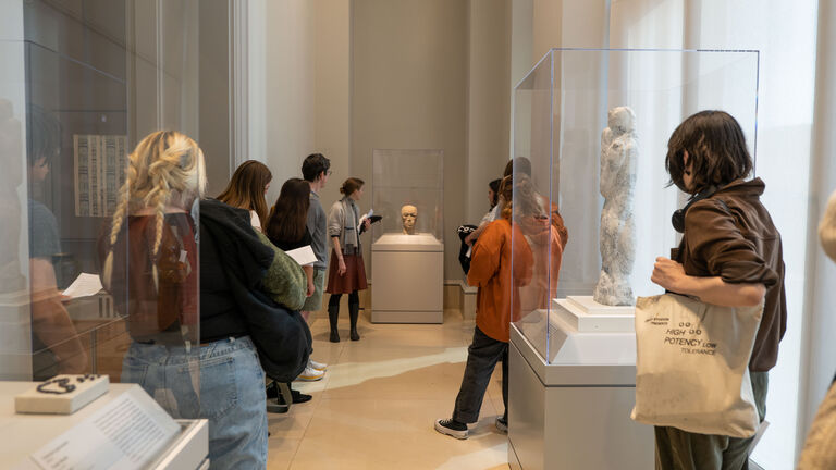 A group of students and an instructor discuss a sculpture at the AIC
