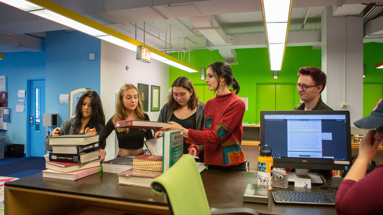 5 students checking out books at Flaxman library