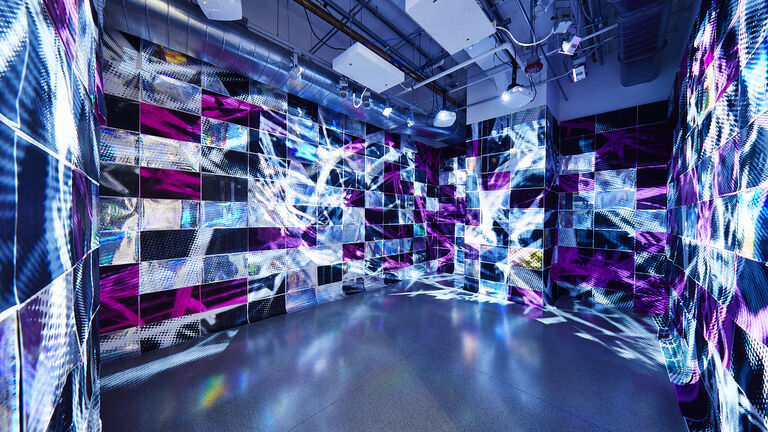 Room filled with titled blue, purple, pink bright lights and fabrics.