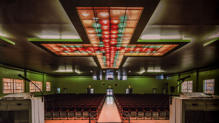 Photograph of a large auditorium with an ornate ceiling fixture