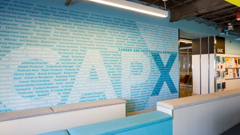 The CAPX offices, showing a large wall made up of text detailing different careers in art and design.