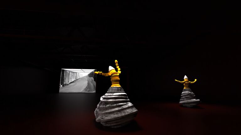 Two yellow and white figures in a dark space.