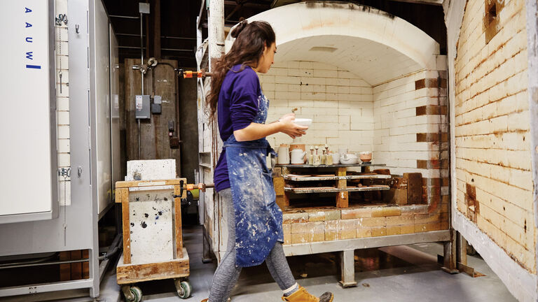 A student walks in front of a kiln