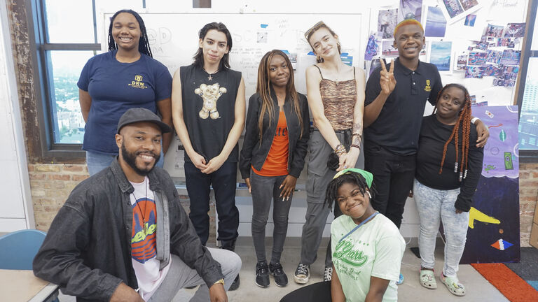 Class instructor and students in the youth class posing for a group shot in a classroom.