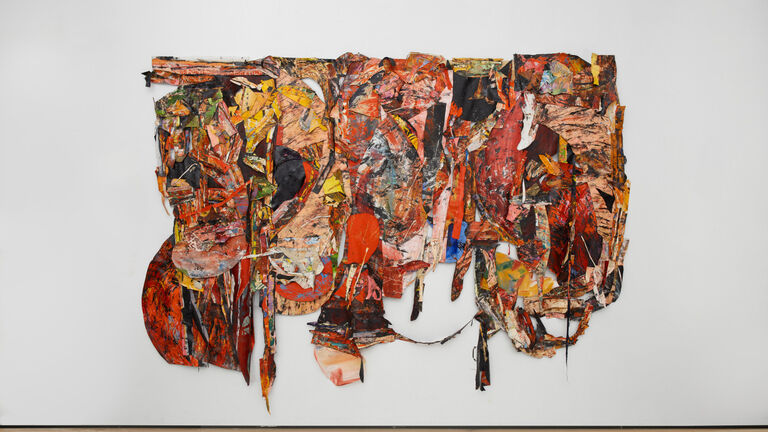 A large textile piece of art with oil painted skins layered on top of fabric using colors like yellow, orange and black. 