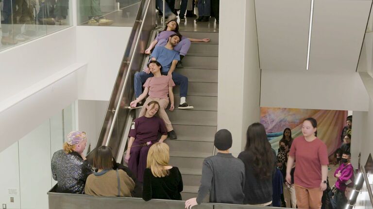 Four people passed out on stairs as an audience watches