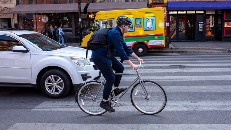 A biker bikes down a city street.