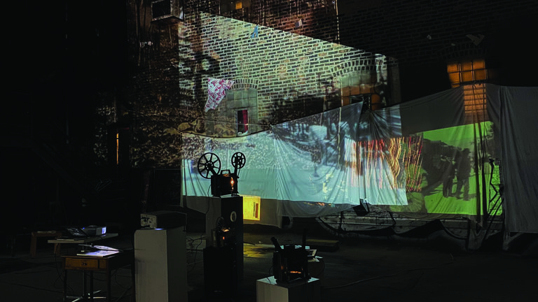 An image of a backyard with projections on multiple white sheets that have been hung around the space.