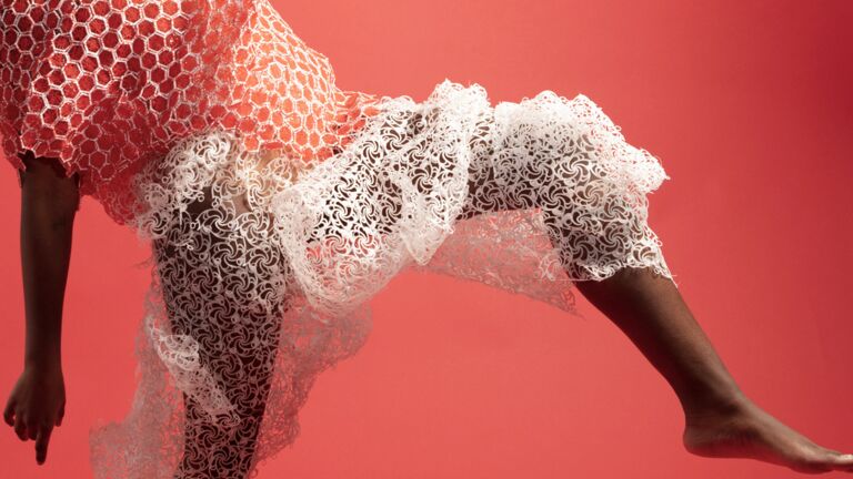 A person wearing a white and red 3D printed garment.