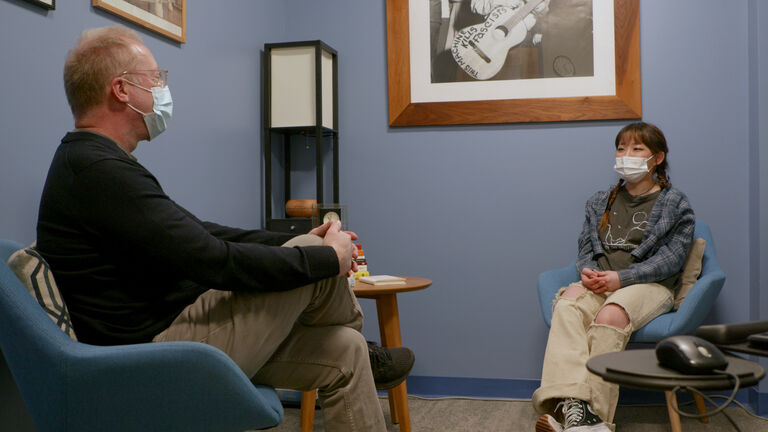 A staff member and a student talk in an office