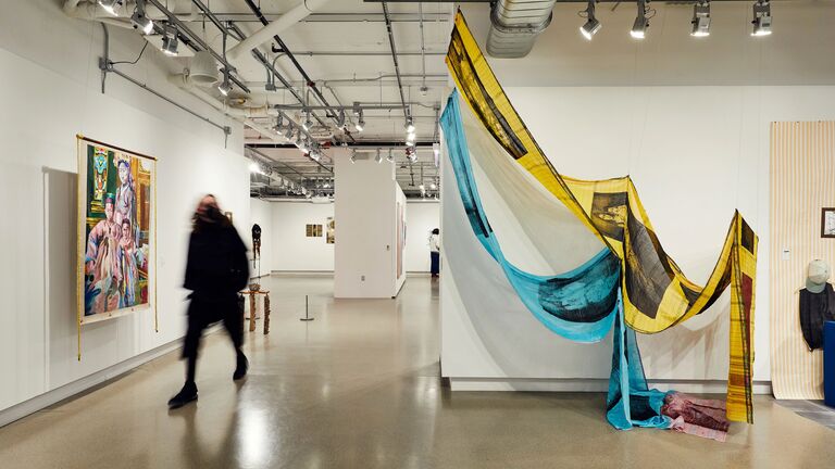 Visitor walking through the undergraduate exhibition at SAIC Galleries