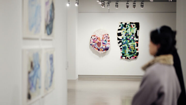 A person viewing wall art in a gallery space