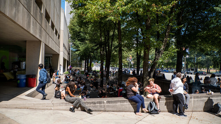 A large gathering of students sitting outside on the SAIC campus.