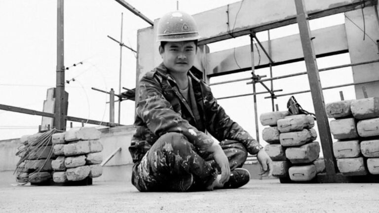 A film still of a soldier sitting on the ground