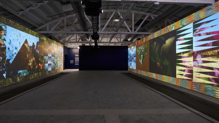 A large gallery's interior with images projected on the walls