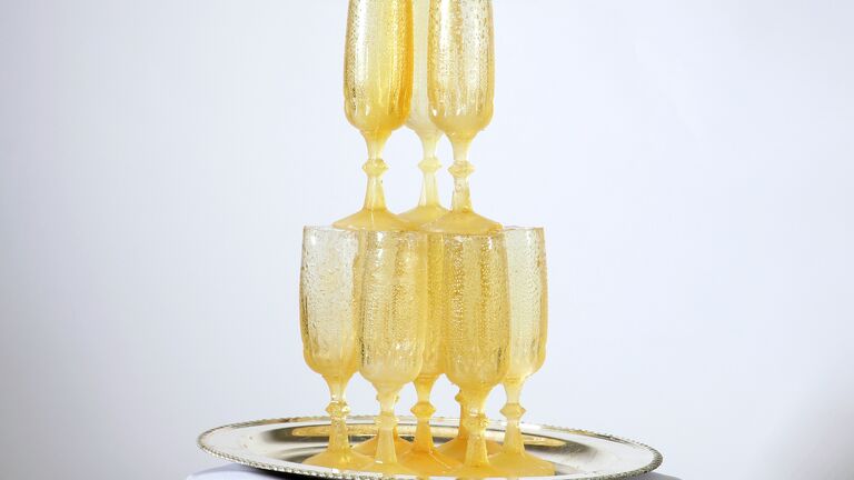 A stack of champagne glasses sits atop a tiny table