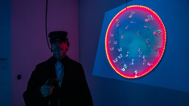 An SAIC art and technology student looks through a VR headset at the 2019 Always Already Alien show.