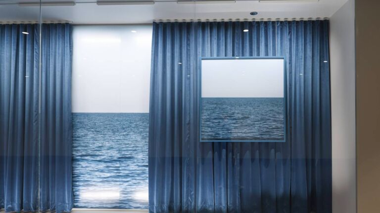 An artwork by Assaf Evron showing curtains opening to the lake