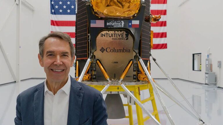 Jeff Koons holds his artwork Moon Phases in front of a spacecraft