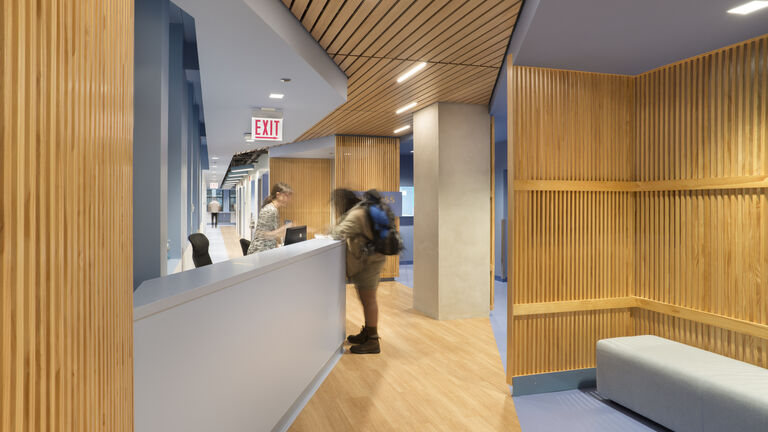 A student standing at the reception desk at the Wellness Center