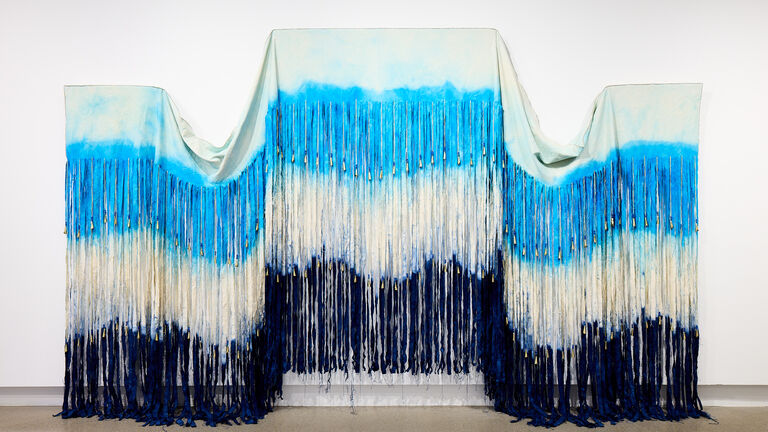Dip dyed wall piece with jingles and beadwork.