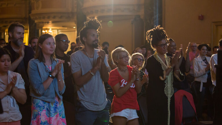 A photo of people applauding at a Low-Res visiting artist and scholars lecture.