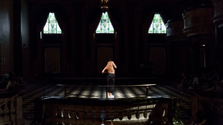 An artist performing on a dark stage 