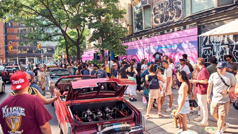 Pop-up event in Los Angeles with a red low-rider car and a crowd around it