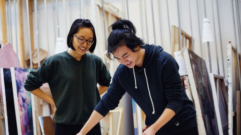 Two Asian students looking at an artwork