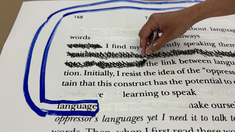Hand writes in black ink on text