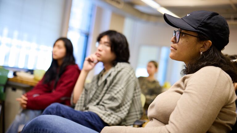 A group of four students of varying ethnicities and genders looking at an out-of-frame subject.
