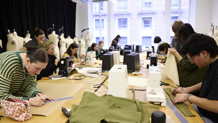 Students at a table with sewing machines working on projects.