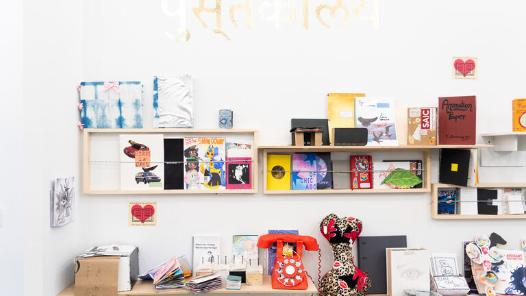 A colorful section of multimedia art pieces against a white wall