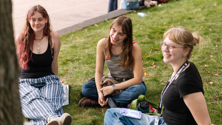 Students sitting outside on the lawn in front of the 280 Building on SAIC's campus.
