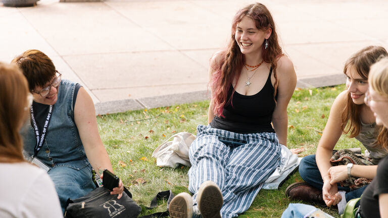 Students sitting outside on the lawn in front of the 280 Building on SAIC's campus.