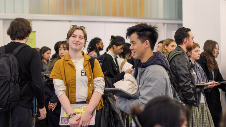 Students of varying ethnicities, ages, and genders gathered indoors. 