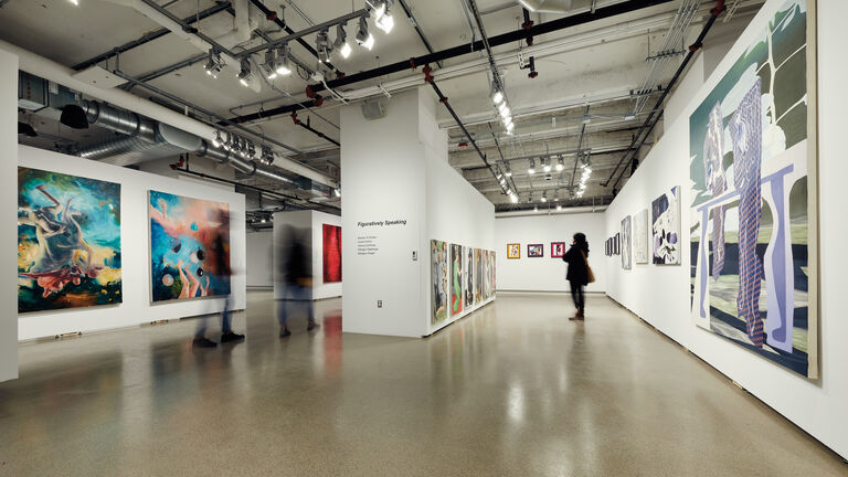Two people walk through SAIC Galleries.