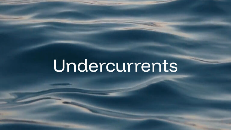 the word "undercurrents" in a white sans serif font on top of a moving body of water close up