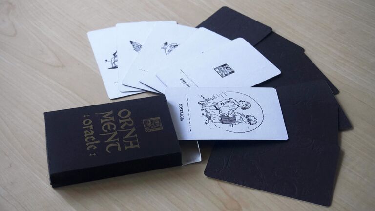 A black box of illustrated cards that says "Ornament Oracle."