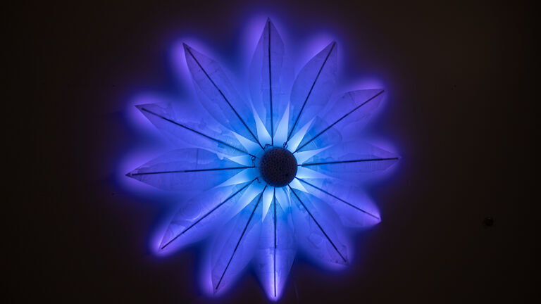 a glowing blue light sculpture of a flower