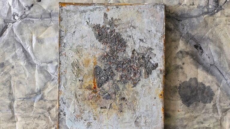 An abstract painting against a rough wall