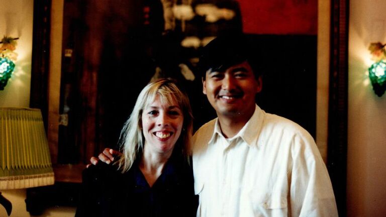 Image of a young woman and a young man standing in front of a painting