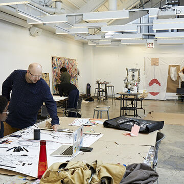 A professor instructing in an open studio.