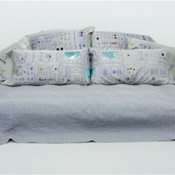 Image of a bed with graphics on the pillows