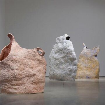 Three metallic sculptures presented in a gallery.