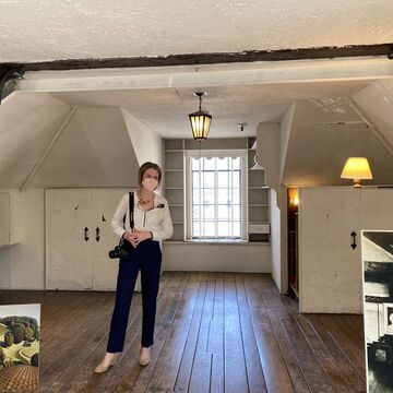 A masked person in a large attic.